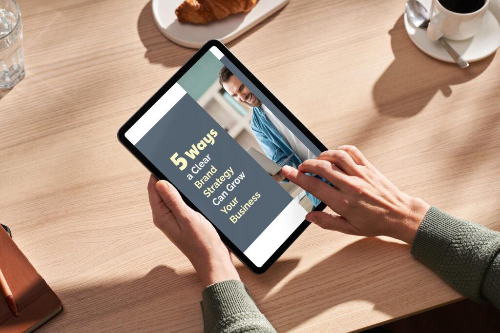 person sitting at table reading a tablet